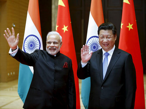 Indian Prime Minister Narendra Modi (L) and Chinese President Xi Jinping wave to journalists before they hold a meeting in Xian, Shaanxi province, China, May 14, 2015. REUTERS