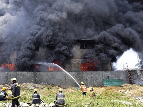 Firefighters attempt to control a raging fire at a factory in Valenzuela City, north of Manila May 13, 2015. A fire at a Philippine rubber slipper factory killed 31 workers on Wednesday and dozens were missing and feared dead, government and fire officials said. REUTERS
