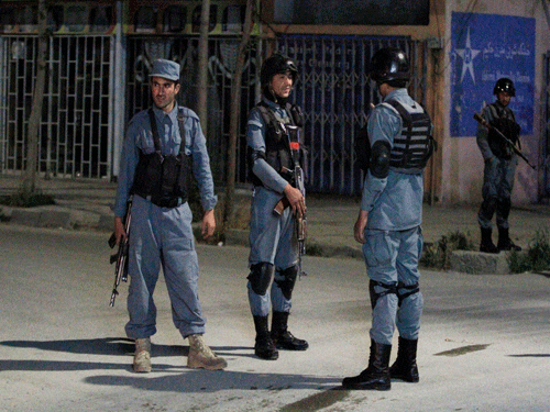 Afghan policemen stand guard near the Park Palace Hotel after an attack by Taliban militants, in Kabul ap photo