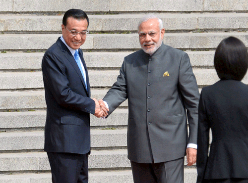Indian Prime Minister Narendra Modi and Chinese Premier Li Keqiang shakes hands during a welcome ceremony outside the Great Hall of the People in Beijing. Reuters