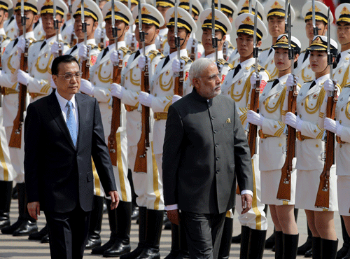 India's Prime Minister Narendra Modi, right, and Chinese Premier Li Keqiang review an honor guard during a welcome ceremony outside the Great Hall of the People in Beijing. AP photo