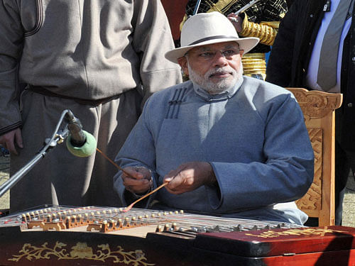 Prime Minister Narendra Modi playing a traditional Mongolian music instrument Yochin at Mini Naadam Festival, in Ulan Bator, Mongolia on Sunday. PTI Photo