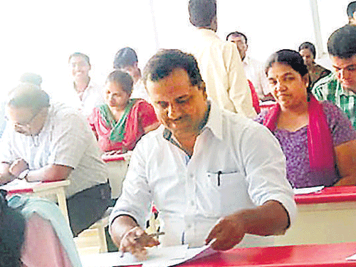Minister for Health and Family Welfare U T Khader (2nd from left) writes Modern Governance paper of Karnataka State Open University exam at Osteen College in the City on  Tuesday. DH&#8200;PHOTO