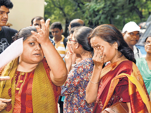 hungama: A parent breaks down during a protest against anomalies in the PU&#8200;results near the DPUE&#8200;office in Bengaluru on Thursday. (Below) Officials clear the way for the car of PU Board director Sushama Godbole amid the tense atmosphere. DH&#8200;PHOTOs