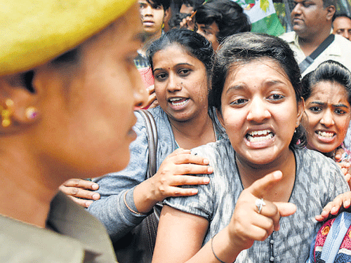 PU students argue with a policewoman during a protest in Bengaluru on Friday. DH Photo