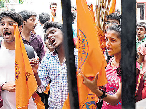 BJP youth wing members protest in front of PU Board in Bengaluru on Saturday.