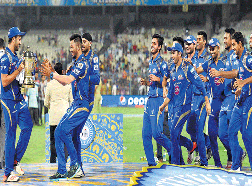 CHAMPSAGAIN:Mumbai Indians players celebrate with the trophy after beating Chennai Super Kings by 41 runs in the IPL 8 final at the Eden Gardens in Kolkata on Sunday. PTI