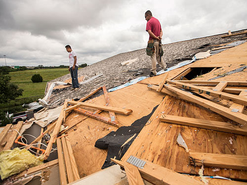 Edgar Mascorro, left, and Emir Nevarez check out the damage on the rooftop at the Silver Springs Apartments in North Austin, Texas. AP Photo