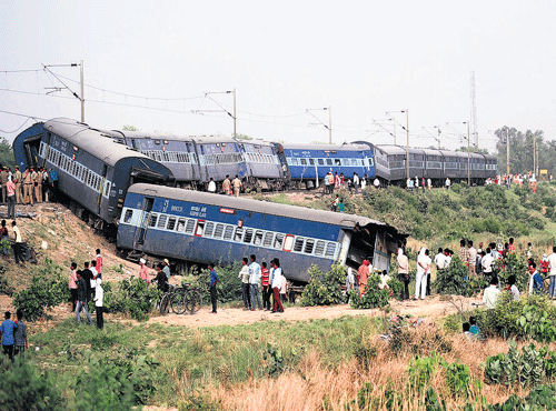 OFF TRACK: Bystanders look at the coaches of the derailed Muri Express train near Sirathu, some65kmfromAllahabad, on Monday.