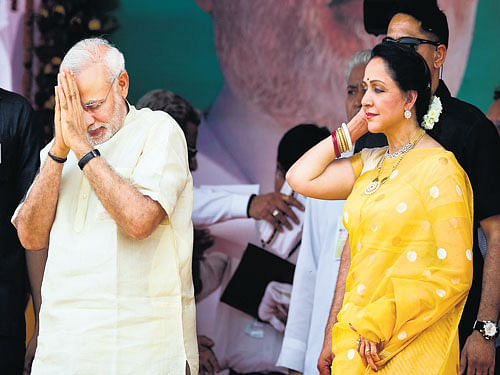 rousing welcome: Prime Minister Narendra Modi greets supporters during the Jan Kalyan Rally on the eve of the Bharatiya Janata Party (BJP) government's first anniversary at Nagla Chandrabhan in Mathura on Monday. BJP MP from Mathura Hema Malini is also seen. ap