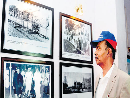 Pradeep Kumar Saxena, General Manager, South Western Railway, looks at the photographs on display at the Bengaluru city railway station on Tuesday. dh Photo