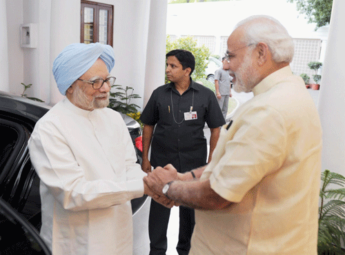HANDCLASP: Prime Minister Narendra Modi and former prime minister Manmohan Singh in a meet at 7 Race Course Road in NewDelhi on Wednesday. PTI
