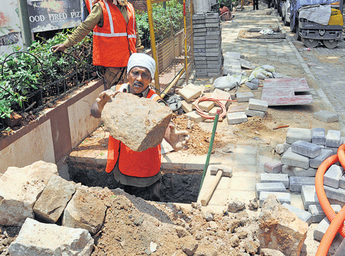 LACK OF COORDINATIONWorkers of BangaloreWater Supply and Sewerage Board digging the footpath on St Mark's Road recently developed under the TenderSURE project. DH PHOTO