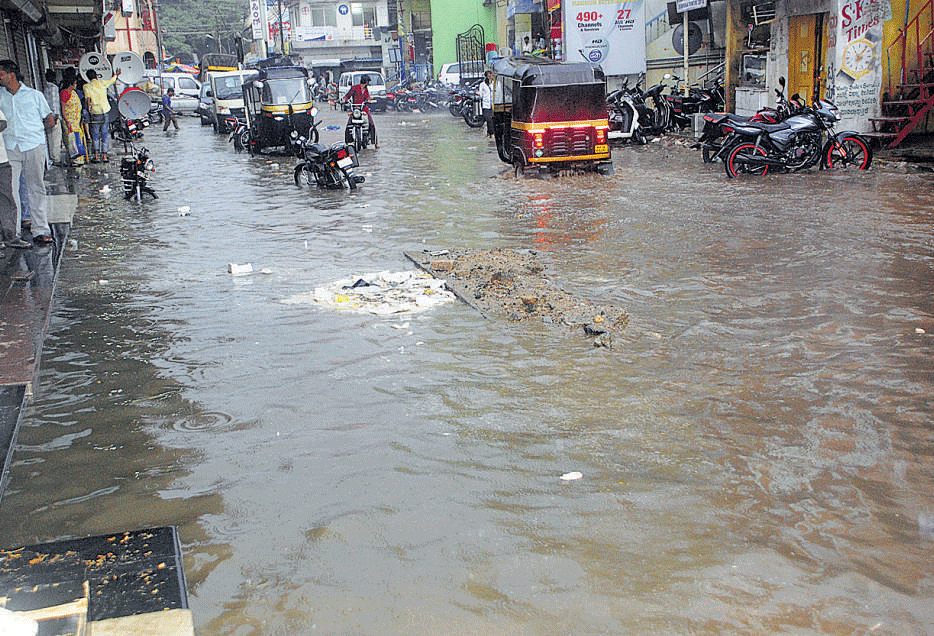 Water overflows on BD Road in Chitradurga following heavy rain on Friday evening. DH PHOTO