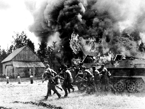 Nazi German soldiers, supported by armored personnel carriers, move into a burning Russian village at an unknown location during the Nazi German invasion of the Soviet Union. AP File Photo