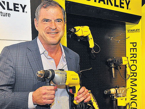 Stanley Black & Decker President and Chief Operating Officer JamesMLoree holds a power tool product during its launch in Bengaluru on Tuesday. DH PHOTO BY B K JANARDHAN