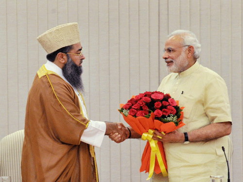Prime Minister Narendra Modi is presented a bouquet during a meeting with a delegation from the Muslim community, led by Imam Umer Ahmed Ilyasi in New Delhi on Tuesday. PTI Photo
