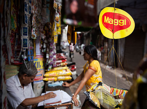 A basket filled with packaged food hangs with a 'Maggi' sign on it outside a shop in New Delhi, India, Wednesday. AP file photo