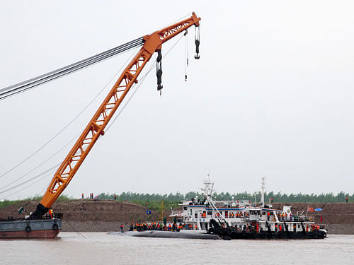 Rescuers conduct search and rescue operations near the capsized ship, center, on the Yangtze River in central China's Hubei province Wednesday, June 3, 2015. AP Photo.