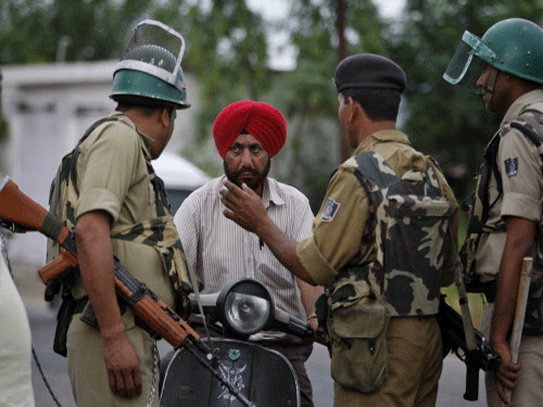 India's Central Reserve Police Force (CRPF) soldiers stop a commuter during a protest Jammu, ap photo