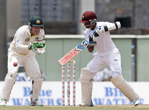 West Indies' Shane Dowrich, right, bats as Australia wicket keeper David Warner looks on during the second innings on the third day of their first cricket Test match in Roseau. AP photo