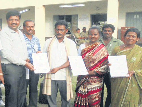 Election officer  Gangappa hands certificates to Suresh, Lakshmi and Nagamma, who won the elections from Kempanahalli Gram Panchayat, Kunigal. DH  photos