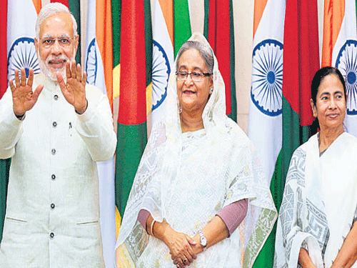 MAKING HISTORY: Prime Minister Narendra Modi with Bangladesh Prime Minister Sheikh Hasina (centre) and West Bengal Chief Minister Mamata Banerjee at the signing of the land border agreement in Dhaka on Saturday. AP