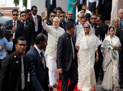 Indian Prime Minister Narendra Modi, center, waves to the gathering as he walks with Bangladesh's Prime Minister Sheikh Hasina, center right, and Chief Minister of the Indian state of West Bengal Mamata Banerjee. AP photo