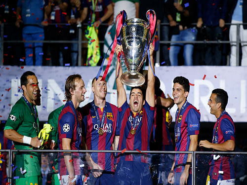 Barcelona's Luis Suarez celebrates with the trophy after the Champions League final soccer match between Juventus Turin and FC Barcelona at the Olympic stadium in Berlin Saturday, June 6, 2015. Barcelona won the match 3-1. AP Photo.