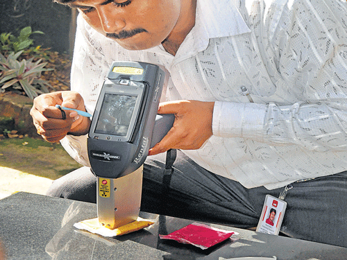 A researcher demonstrates how to scan for lead in food using the field portable X-ray fluorescence machine in Bengaluru on Monday. DH Photo