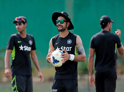 India's test match captain Virat Kohli, center, holds a soccer ball during a practice session ahead of their test cricket match against Bangladesh in Dhaka, Bangladesh. AP photo