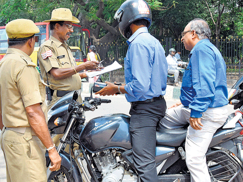 TIGHT VIGIL: Policemen check two-wheeler riders onBRAmbedkar Road near Vikasa Soudha on Thursday. Police have intensified the checkings as incidents of bike-borne miscreants snatching chains are on the rise. DH PHOTO
