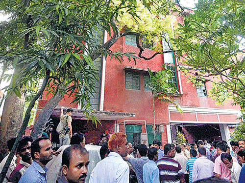 People gather in front of Partha De's house in Kolkata on Thursday. PTI