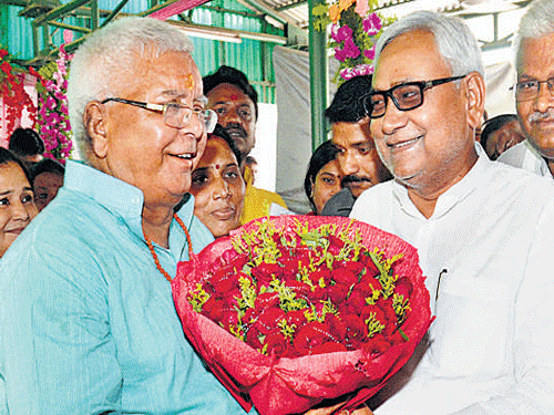Bihar Chief Minister Nitish Kumar greets RJD chief Lalu Prasad on his 68th birthday in Patna on Thursday. PTI