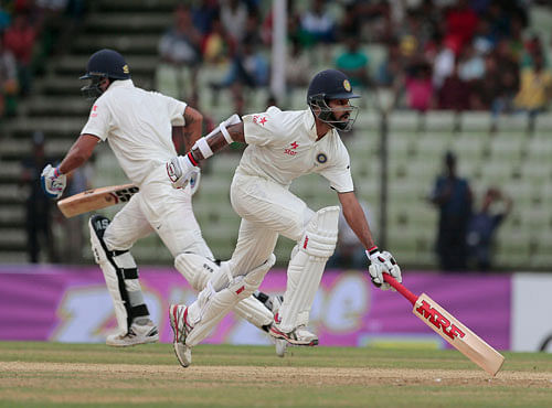 India's Murali Vijay, left, and Shikhar Dhawan run between wickets during the first day of their test cricket match against Bangladesh in Fatullah. AP photo