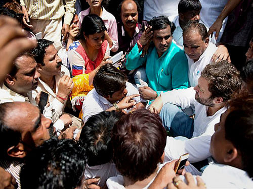 Congress Vice President Rahul Gandhi listening to Sanitation workers during their ongoing protest for dues, at Patparganj in East Delhi on Friday. PTI Photo