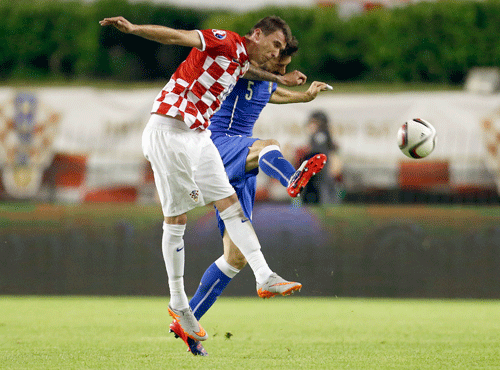 taly's Davide Astori, rear, is challenged by Croatia's Mario Mandzukic during the Euro 2016 Group H qualifying soccer match between Croatia and Italy, in Split, Croatia. AP photo