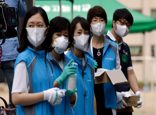 South Korean health workers from a community health center wearing masks as a precaution against MERS, Middle East Respiratory Syndrome, virus, wait to check examinees. AP photo