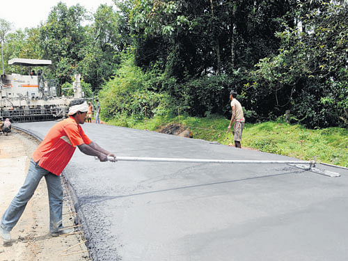slow and tedious: Pavement Quality Concrete (the final layer) is being laid on the Shiradi ghat stretch near Marenahalli in Sakleshpur taluk, Hassan district. (R) Although traffic is completely banned on the Shiradi stretch, some vehicles continue to ply. dh Photos