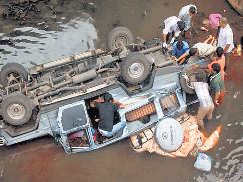 People search the mangled remains of the ill-fated vehicle on Saturday.PTI Photo