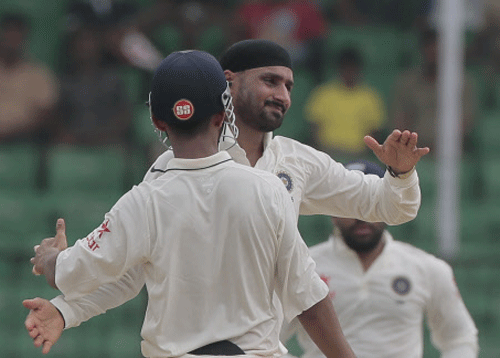 India's Harbhajan Singh, face to the camera, celebrates with his teammates after the dismissal of Bangladesh's Mominul Haque during the fourth day of their test cricket match. AP photo