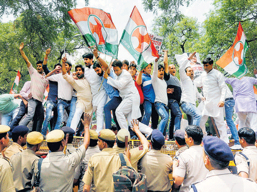 Congress activists shout slogans as they stand on police barricades during a protest against External Affairs Minister Sushma Swaraj in New Delhi on Monday. REUTERS Photo