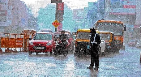 A traffic constable braves heavy rain while regulating vehicles in  Mangaluru on Wednesday. DH PHOTO