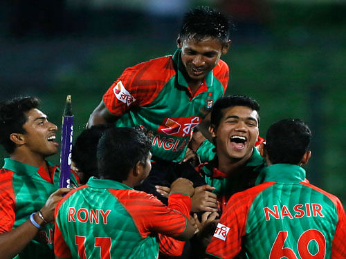 Bangladesh's players lift Mustafizur Rahman, center, as they celebrate their win over India during their second one-day international cricket match in Dhaka, Bangladesh, Sunday, June 21, 2015. AP Photo.