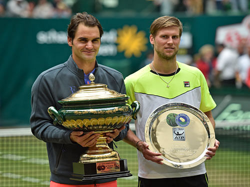 Roger Federer of Switzerland, left, holds the trophy after winning the final match against Andreas Seppi of Italy, right, at the Gerry Weber Open ATP tennis tournament in Halle, Germany, Sunday, June 21, 2015. Federer defeated Seppi with 7-6 and 6-4. AP Photo.