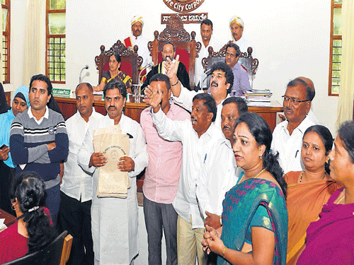 Corporators stage a protest, demanding subsidies to construct houses under Gruha Bhagya, even for houses constructed at revenue layouts, in Mysuru, on Monday. DH photo