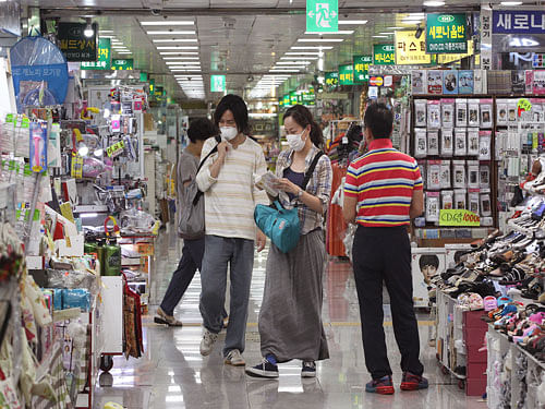A couple wearing masks as a precaution against the Middle East respiratory syndrome walk through a shopping alley in Seoul, South Korea Tuesday, June 23, 2015. The outbreak of MERS has caused panic in South Korea and the heir of the Samsung business empire bowed deep in apology Tuesday as criticism mounted over a Samsung hospital's role in spreading MERS in the country. AP Photo.