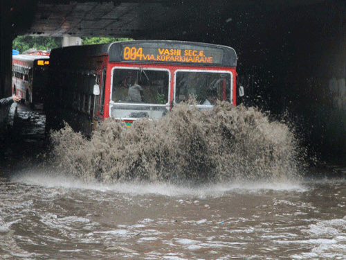 Vehicles wade through a waterlogged road after heavy downpour in Mumbai on Tuesday. PTI