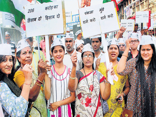 AAP workers protest against Maharashtra Rural Development Minister Pankaja Munde demanding her immediate resignation in Nagpur on Friday. PTI