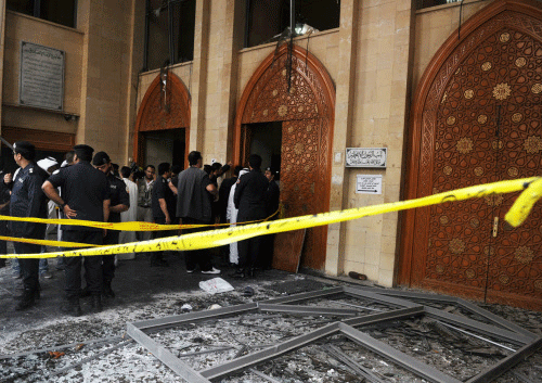 Security forces and officials gather at a Shiite mosque after a deadly blast claimed by the Islamic State group that struck worshippers attending Friday prayers in Kuwait City.AP